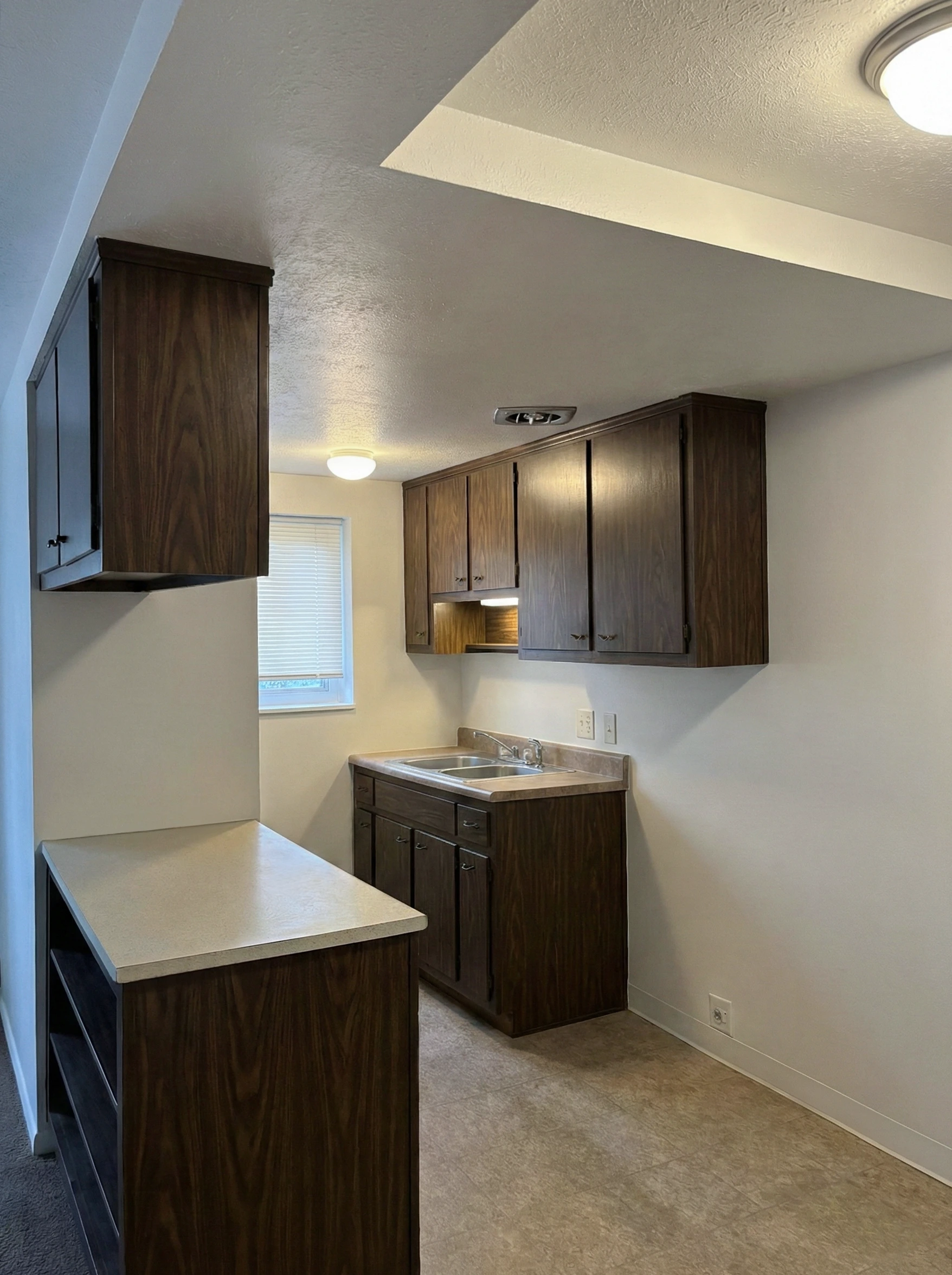 Apartment kitchen with dark wood cabinets and counter space